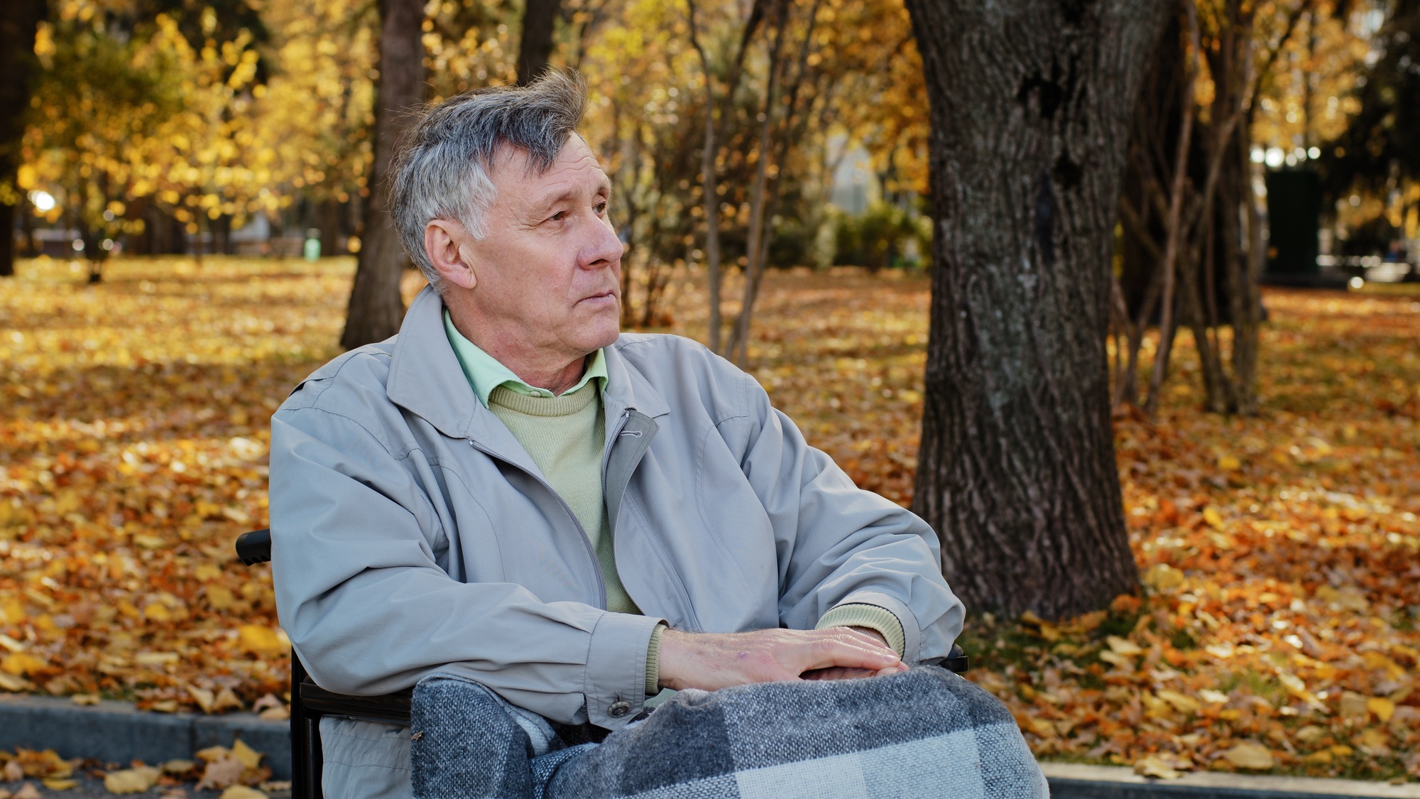 Mature outdoors upset senior retired caucasian man grandfather with disability sit alone at