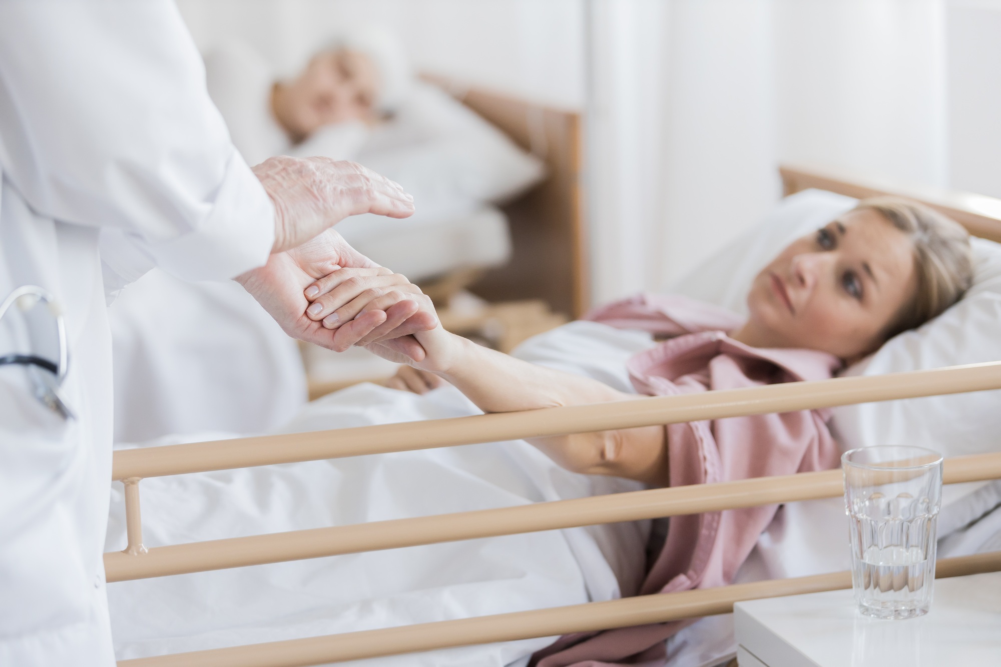 Woman holding doctor's hand